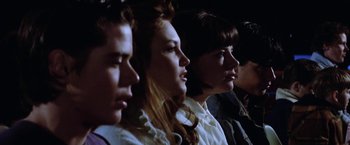 Movie still from “The Outsiders” (1983), directed by Francis Ford Coppola – A group of young people sitting in a row; Close Up shot, Low angle