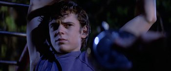 Movie still from “The Outsiders” (1983), directed by Francis Ford Coppola – A young man holding a camera in a dark place; Close Up shot, Low angle