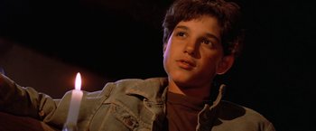Movie still from “The Outsiders” (1983), directed by Francis Ford Coppola – A young man in a brown shirt and a jean jacket; Close Up shot, Low angle