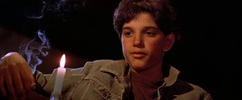 Movie still from “The Outsiders” (1983), directed by Francis Ford Coppola – A young boy with a brown shirt and a jean jacket; Close Up shot, Low angle