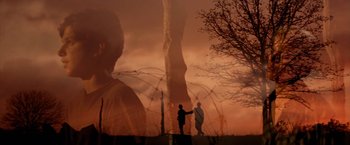 Movie still from “The Outsiders” (1983), directed by Francis Ford Coppola – Two people are shaking hands in front of an image of a waterfall; Medium shot, Low angle