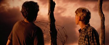 Movie still from “The Outsiders” (1983), directed by Francis Ford Coppola – Two people standing next to a tree in front of a cloudy sky; Close Up shot, Over the shoulder angle
