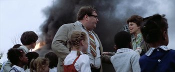 Movie still from “The Outsiders” (1983), directed by Francis Ford Coppola – A man and a little girl standing next to each other in front of smoke; Medium shot, Low angle
