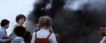 Movie still from “The Outsiders” (1983), directed by Francis Ford Coppola – A little girl with pigtails standing in front of a black cloud of smoke; Close Up shot, High angle