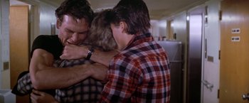 Movie still from “The Outsiders” (1983), directed by Francis Ford Coppola – A group of people hugging each other in a room; Medium shot, Over the shoulder angle