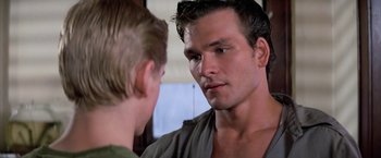 Movie still from “The Outsiders” (1983), directed by Francis Ford Coppola – A young man looking at another young man in front of a window; Close Up shot, Over the shoulder angle