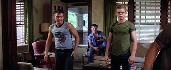 Movie still from “The Outsiders” (1983), directed by Francis Ford Coppola – A group of young men standing in a living room; Medium shot, Low angle