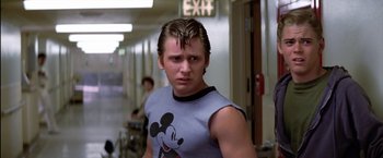 Movie still from “The Outsiders” (1983), directed by Francis Ford Coppola – A young man with a mickey mouse shirt on; Medium shot, Low angle