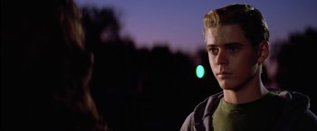 Movie still from “The Outsiders” (1983), directed by Francis Ford Coppola – A young man standing in front of a green light; Close Up shot, Over the shoulder angle