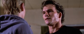 Movie still from “The Outsiders” (1983), directed by Francis Ford Coppola – A person wearing a black t - shirt; Close Up shot, Low angle