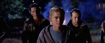 Movie still from “The Outsiders” (1983), directed by Francis Ford Coppola – A group of young men standing next to each other in the dark; Medium shot, Low angle