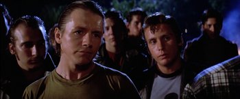 Movie still from “The Outsiders” (1983), directed by Francis Ford Coppola – A group of men standing next to each other in the dark; Close Up shot, Low angle