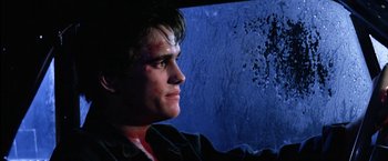 Movie still from “The Outsiders” (1983), directed by Francis Ford Coppola – A young man with a bruised face looking off into the distance; Close Up shot, Low angle