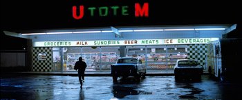 Movie still from “The Outsiders” (1983), directed by Francis Ford Coppola – A man walking in the rain next to an old truck; Extreme Wide shot, Low angle