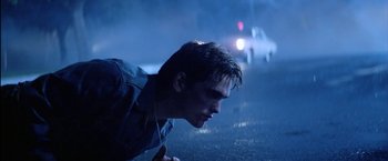 Movie still from “The Outsiders” (1983), directed by Francis Ford Coppola – A young man laying on the ground in the rain; Close Up shot, Low angle