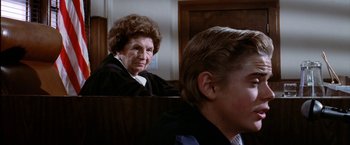 Movie still from “The Outsiders” (1983), directed by Francis Ford Coppola – An older woman and a young man in a courtroom; Close Up shot, Over the shoulder angle