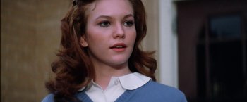 Movie still from “The Outsiders” (1983), directed by Francis Ford Coppola – A person wearing a shirt and sweater; Close Up shot, Low angle