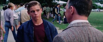 Movie still from “The Outsiders” (1983), directed by Francis Ford Coppola – A young man talking to an older man in a park; Close Up shot, Over the shoulder angle