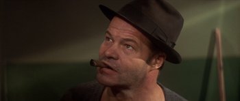 Movie still from “The Owl and the Pussycat” (1970), directed by Herbert Ross – A person wearing a hat and smoking a cigar; Close Up shot, Low angle