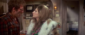 Movie still from “The Owl and the Pussycat” (1970), directed by Herbert Ross – A woman with long hair wearing a fur coat; Medium shot, Over the shoulder angle