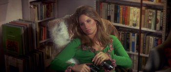 Movie still from “The Owl and the Pussycat” (1970), directed by Herbert Ross – A woman sitting in a chair holding a camera; Medium shot, High angle