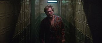 Movie still from “The Owl and the Pussycat” (1970), directed by Herbert Ross – A man wearing a robe and glasses in an alley way; Medium shot, Low angle