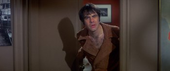 Movie still from “The Owl and the Pussycat” (1970), directed by Herbert Ross – A man in a brown robe looking into a bathroom mirror; Medium shot, Over the shoulder angle