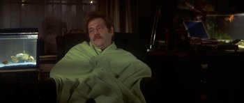 Movie still from “The Owl and the Pussycat” (1970), directed by Herbert Ross – A man wrapped in a blanket sitting in a chair; Medium shot, High angle