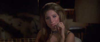 Movie still from “The Owl and the Pussycat” (1970), directed by Herbert Ross – A beautiful woman sitting on a couch holding a cell phone; Close Up shot, High angle