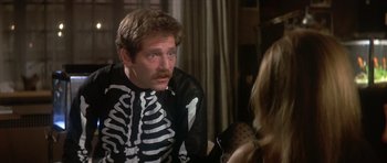 Movie still from “The Owl and the Pussycat” (1970), directed by Herbert Ross – A man in a skeleton costume sitting next to a woman; Medium shot, Over the shoulder angle