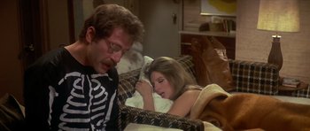 Movie still from “The Owl and the Pussycat” (1970), directed by Herbert Ross – A man and a woman laying on a couch; Medium shot, Over the shoulder angle