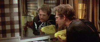 Movie still from “The Owl and the Pussycat” (1970), directed by Herbert Ross – A man with glasses looking in the mirror; Close Up shot, Over the shoulder angle