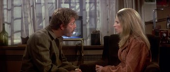 Movie still from “The Owl and the Pussycat” (1970), directed by Herbert Ross – A man and a woman sitting in front of a television; Medium shot, Over the shoulder angle