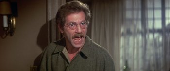 Movie still from “The Owl and the Pussycat” (1970), directed by Herbert Ross – An older man wearing glasses and a gray jacket; Close Up shot, Over the shoulder angle
