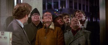 Movie still from “The Owl and the Pussycat” (1970), directed by Herbert Ross – A group of men standing next to each other; Medium shot, Low angle