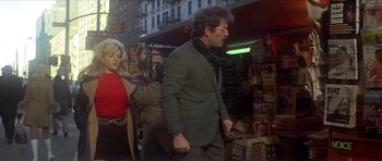 Movie still from “The Owl and the Pussycat” (1970), directed by Herbert Ross – A man walking down the street in front of a store; Medium shot, Low angle