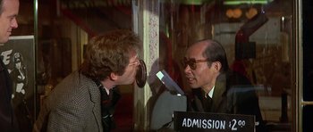 Movie still from “The Owl and the Pussycat” (1970), directed by Herbert Ross – A man talking to another man in a room; Medium shot, Over the shoulder angle