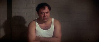 Movie still from “The Owl and the Pussycat” (1970), directed by Herbert Ross – A man in a white tank top is looking at the camera; Close Up shot, Low angle