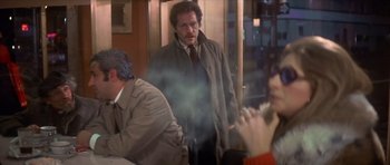 Movie still from “The Owl and the Pussycat” (1970), directed by Herbert Ross – A group of people sitting at a table; Medium shot, Over the shoulder angle