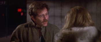 Movie still from “The Owl and the Pussycat” (1970), directed by Herbert Ross – A man wearing glasses and a jacket talking to a woman in front of him; Close Up shot, Over the shoulder angle