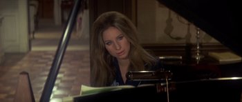 Movie still from “The Owl and the Pussycat” (1970), directed by Herbert Ross – A beautiful young lady sitting at a piano; Close Up shot, High angle