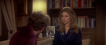 Movie still from “The Owl and the Pussycat” (1970), directed by Herbert Ross – A woman is talking to a man in front of a book shelf; Medium shot, Over the shoulder angle