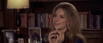 Movie still from “The Owl and the Pussycat” (1970), directed by Herbert Ross – A woman sitting in front of a mirror holding a cigarette in her mouth; Close Up shot, Over the shoulder angle