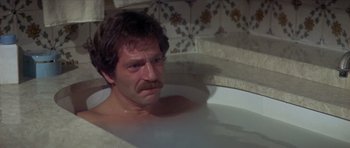 Movie still from “The Owl and the Pussycat” (1970), directed by Herbert Ross – A man with a mustache sitting in a bath tub; Close Up shot, High angle