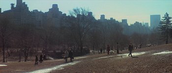 Movie still from “The Owl and the Pussycat” (1970), directed by Herbert Ross – A group of people walking on a path in a city park; Extreme Wide shot, Low angle