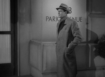 Movie still from “The Palm Beach Story” (1942), directed by Preston Sturges – A black and white photo of a man wearing a hat and a coat; Medium shot, Low angle