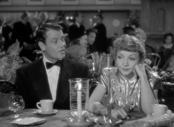 Movie still from “The Palm Beach Story” (1942), directed by Preston Sturges – A man and a woman sitting at a dinner table; Medium shot, Over the shoulder angle