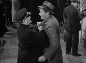 Movie still from “The Palm Beach Story” (1942), directed by Preston Sturges – Two men in hats and jackets are fixing their ties; Medium shot, Over the shoulder angle
