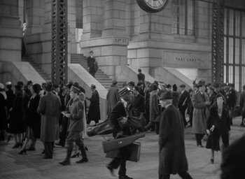 Movie still from “The Palm Beach Story” (1942), directed by Preston Sturges – A black and white photo of a crowd of people walking down a street; Extreme Wide shot, High angle