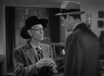 Movie still from “The Palm Beach Story” (1942), directed by Preston Sturges – A man in a suit and hat talking to another man in a suit and hat; Medium shot, Over the shoulder angle
